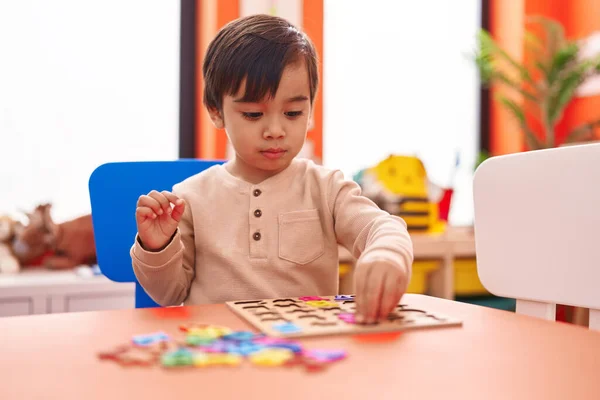 Adorable Hispanic Boy Playing Maths Puzzle Game Sitting Table Kindergarten — Stockfoto