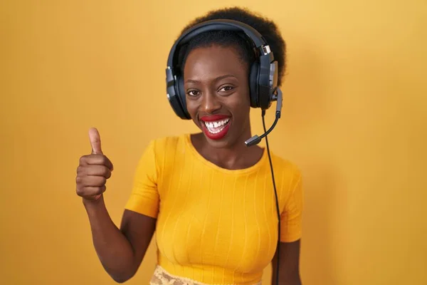 African Woman Curly Hair Standing Yellow Background Wearing Headphones Doing — Stock Photo, Image