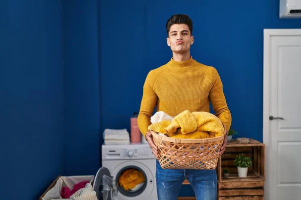 Young Hispanic Man Holding Laundry Basket Looking Camera Blowing Kiss — Stock Photo, Image