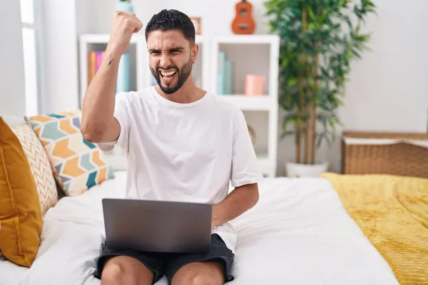 Hispanic Young Man Using Computer Laptop Sitting Bed Annoyed Frustrated — Stockfoto