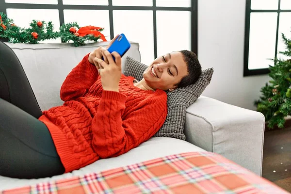 Jong Hispanic Vrouw Met Behulp Van Smartphone Liggend Door Kerstboom — Stockfoto