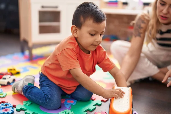 Teacher Toddler Playing Cars Toy Sitting Floor Kindergarten — Stockfoto