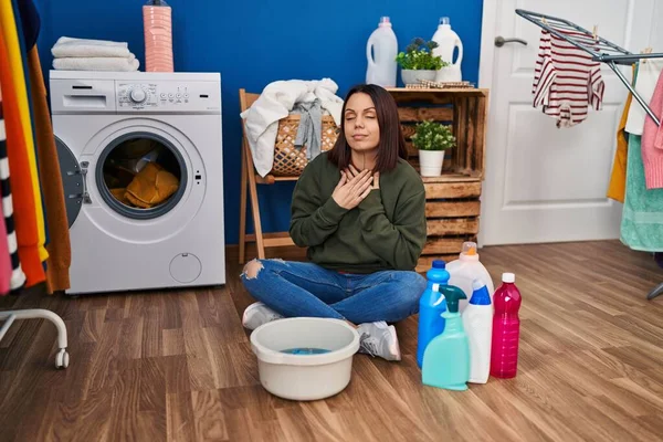 Young hispanic woman doing laundry washing by hand smiling with hands on chest with closed eyes and grateful gesture on face. health concept.
