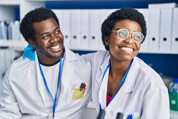 アフリカ系アメリカ人の男性と女性の科学者は自信を持って抱き合って笑っています — ストック写真