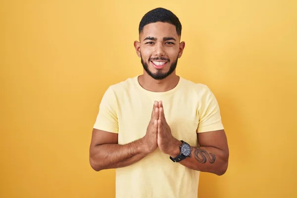 Young Hispanic Man Standing Yellow Background Praying Hands Together Asking — Stock Photo, Image