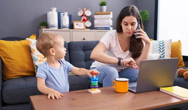 Mother and son stressed talking on smartphone playing at home