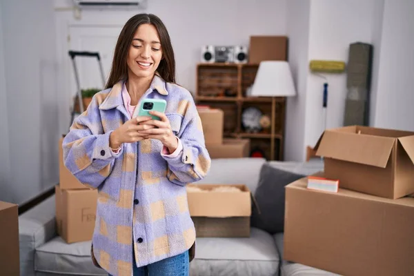 Young Beautiful Hispanic Woman Smiling Confident Using Smartphone New Home — Stockfoto