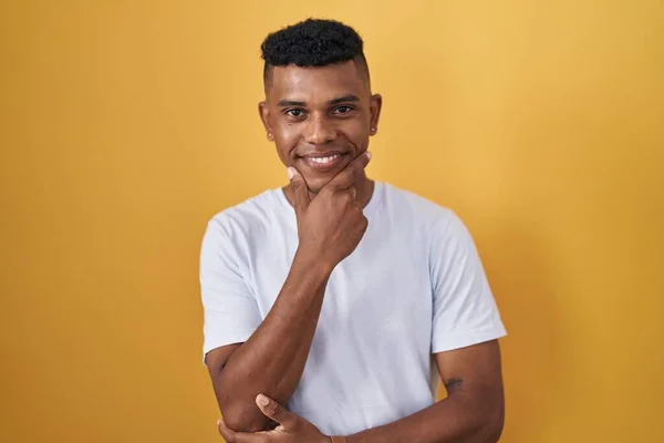 Homem Hispânico Jovem Sobre Fundo Amarelo Olhando Confiante Para Câmera — Fotografia de Stock