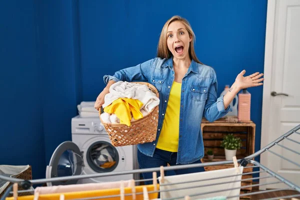Young Blonde Woman Holding Laundry Basket Celebrating Crazy Amazed Success — Foto Stock