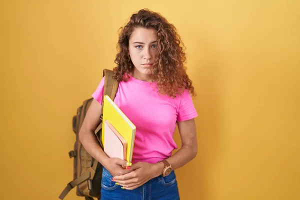 Young caucasian woman wearing student backpack and holding books depressed and worry for distress, crying angry and afraid. sad expression.