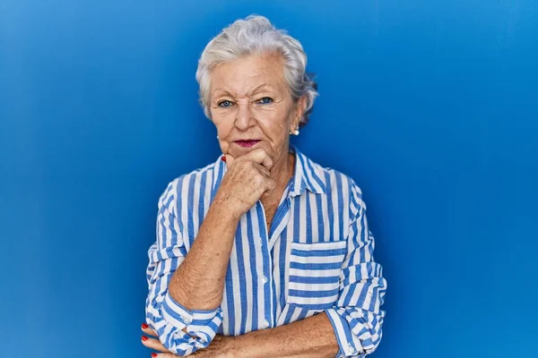 Senior Γυναίκα Γκρίζα Μαλλιά Στέκεται Πάνω Από Μπλε Φόντο Αναζητούν — Φωτογραφία Αρχείου