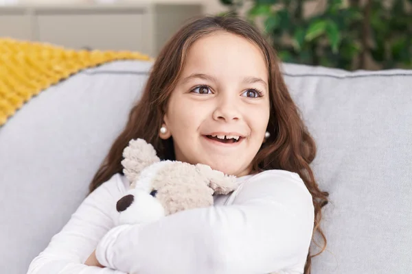 Adorable Hispanic Girl Hugging Teddy Bear Sitting Sofa Home — Stok fotoğraf