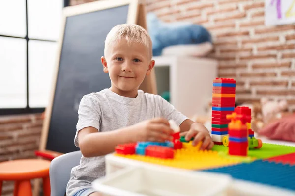 愛らしい幼児遊びます建設ブロックでテーブルの上に座っ教室 — ストック写真