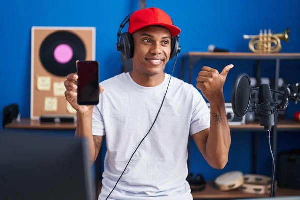 Young Hispanic Man Listening Music Wearing Headphones Showing Smartphone Screen — Stock fotografie