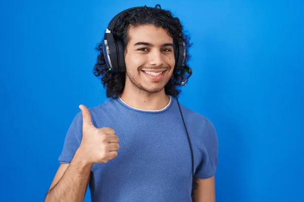 Hispanic Man Curly Hair Listening Music Using Headphones Doing Happy — Stockfoto