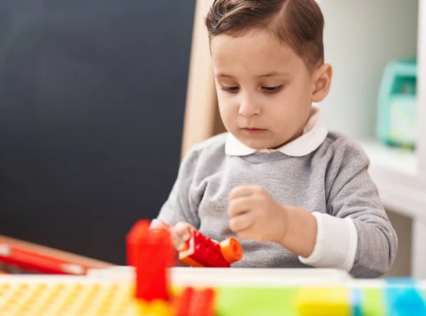 愛らしいヒスパニック幼児遊びます建設ブロックでテーブルの上に座っ幼稚園 — ストック写真