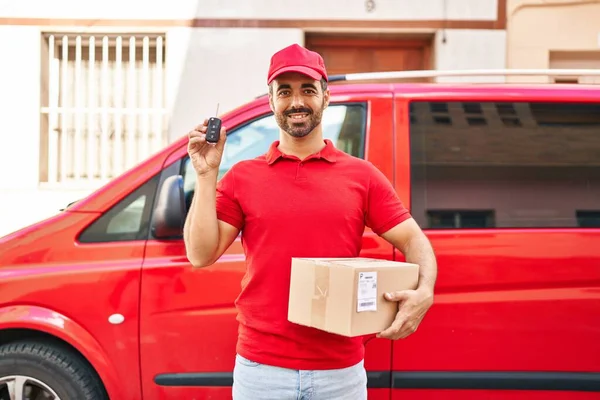 Genç İspanyol kurye paketini ve araba anahtarını sokakta tutuyor.