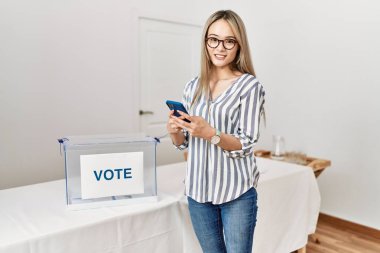 Genç Çinli kadın seçmen okulunda akıllı telefon oylaması yapıyor.