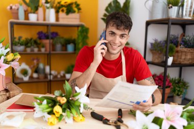 Çiçekçide akıllı telefondan konuşan İspanyol bir çiçekçi.