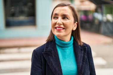 Middle age woman business executive smiling confident standing at street