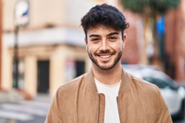 Sokakta kendinden emin gülümseyen İspanyol genç adam.