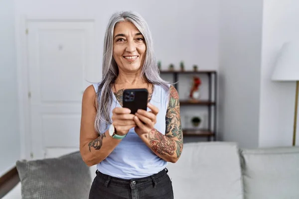Grauhaarige Frau Mittleren Alters Lächelt Selbstbewusst Mit Smartphone Hause — Stockfoto