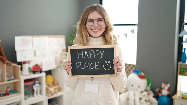 Young Blonde Woman Preschool Teacher Holding Blackboard Happy Place Message — Stockfoto