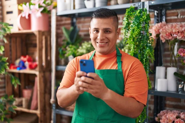 Joven Florista Latino Sonriendo Confiado Usando Teléfono Inteligente Tienda Flores —  Fotos de Stock