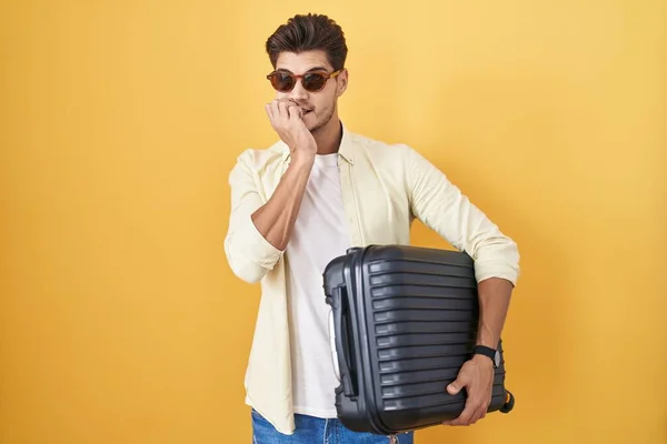Young Hispanic Man Holding Suitcase Going Summer Vacation Looking Stressed — Stockfoto