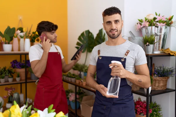 Two Hispanic Men Florists Holding Sprayer Talking Smartphone Flower Shop — Stockfoto