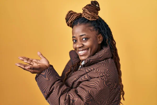 African Woman Braided Hair Standing Yellow Background Pointing Aside Hands — ストック写真