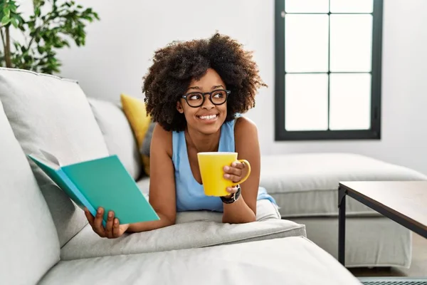 Mladá Africká Americká Žena Pije Kávu Čtení Knihy Doma — Stock fotografie