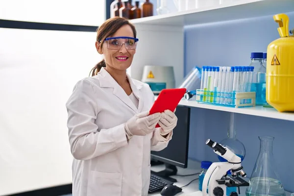 中年妇女穿着科学家制服 在实验室使用触摸板 — 图库照片