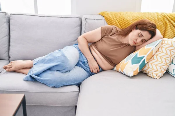 Young Woman Suffering Menstrual Pain Lying Sofa Home — Foto de Stock