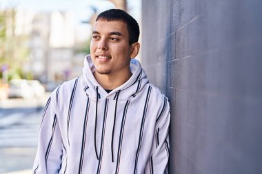 Sokakta kendine güvenen genç adam gülümsüyor