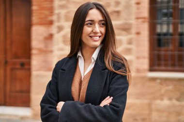 Sokakta kollarını kavuşturmuş genç, güzel İspanyol bir kadın.