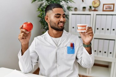 Diyetisyen üniformalı genç bir Arap klinikte sağlıklı beslenme talep ediyor.