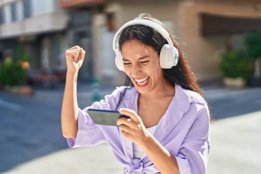 Genç, güzel İspanyol kadın gülümsüyor. Sokakta oyun oynarken kendine güveniyor.