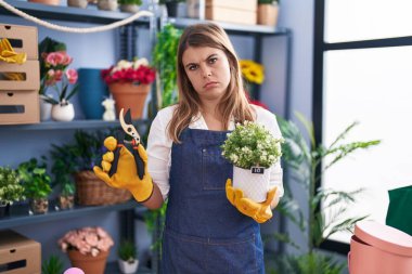 Young hispanic woman working at florist shop depressed and worry for distress, crying angry and afraid. sad expression. 