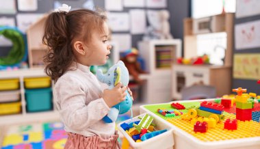 Anaokulunda elinde fil oyuncağı tutan tapılası İspanyol bebek.