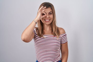 Genç İspanyol kadın izole edilmiş arka planda duruyor. El hareketleriyle gülümsüyor, gözleriyle mutlu yüzlere bakıyor.. 