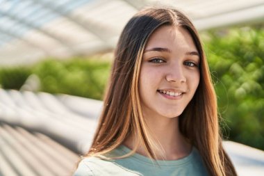 Parktaki kameraya bakarak kendine güvenen sevimli bir kız.