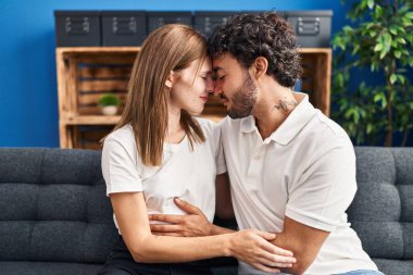 Man and woman smiling confident hugging each other at home