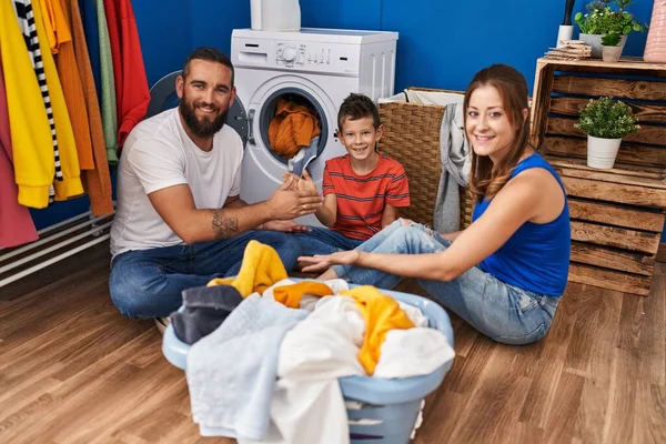 Family playing game washing clothes at laundry room