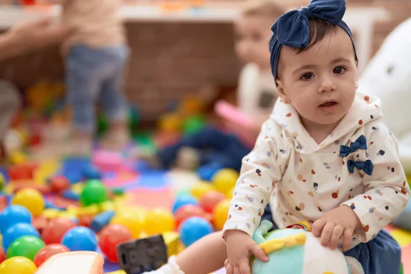 愛らしい幼児遊びとともにおもちゃで床に座って幼稚園 — ストック写真