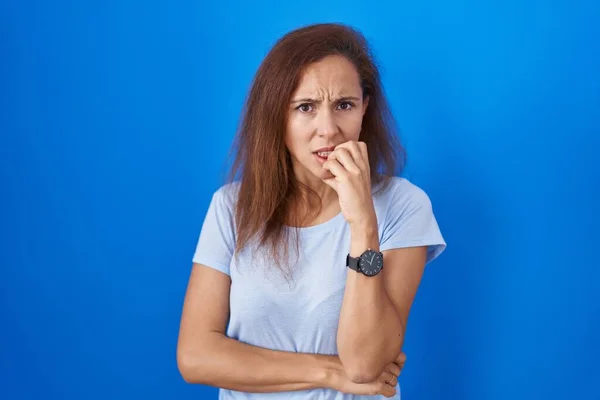 Brunette Woman Standing Blue Background Looking Stressed Nervous Hands Mouth — Stok fotoğraf