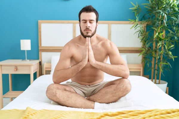 Young Hispanic Man Doing Yoga Exercise Sitting Bed Bedroom — Zdjęcie stockowe