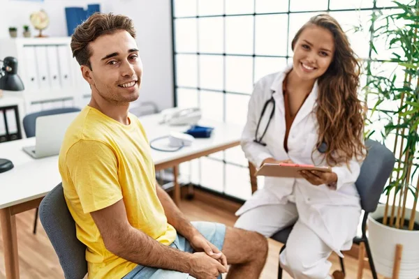 Man and woman having doctor visit speaking at clinic