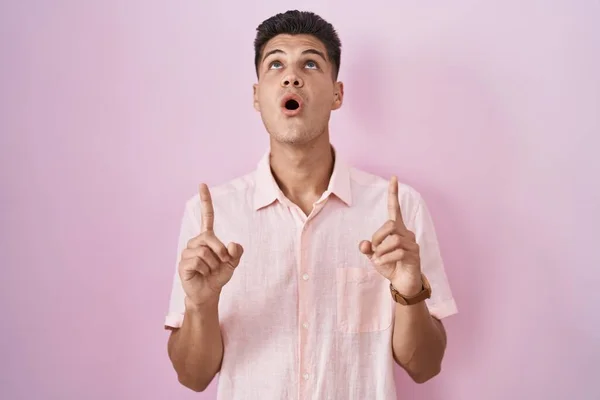 Young Hispanic Man Standing Pink Background Amazed Surprised Looking Pointing — Stock fotografie