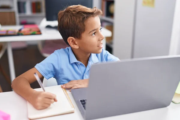 Adorable Hispanic Boy Student Using Computer Writing Notebook Classroom — Stockfoto